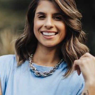 Beatriz, sorrindo, em foto ao ar livre